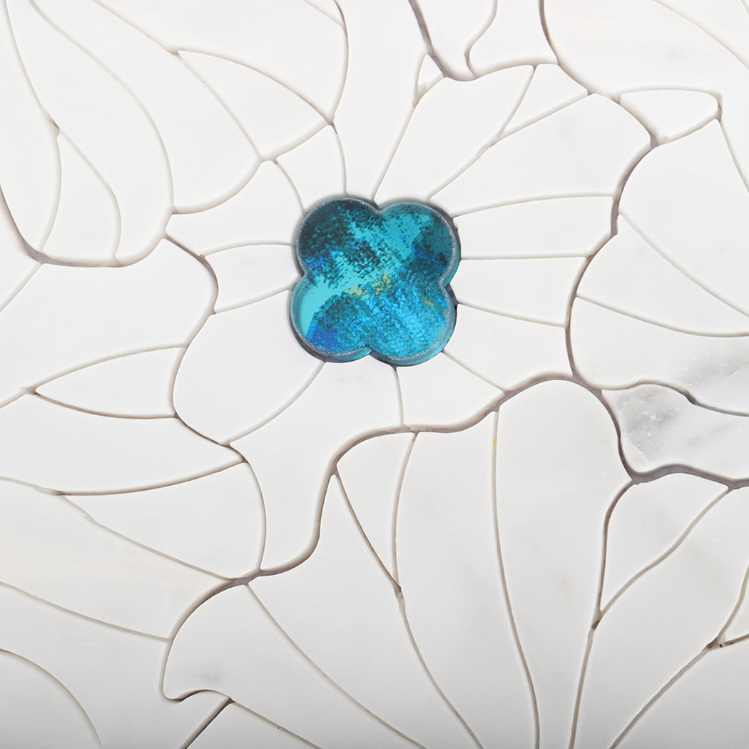 Close-up view of turquoise glass insert on flower marble mosaic tile.