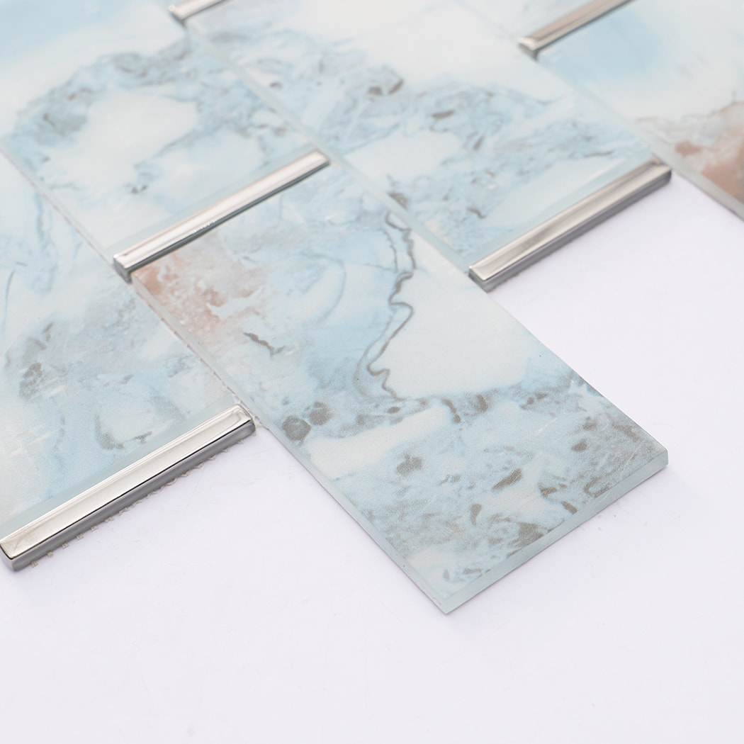 Edge detail of blue gray glass subway mosaic tiles with electroplated glass accents