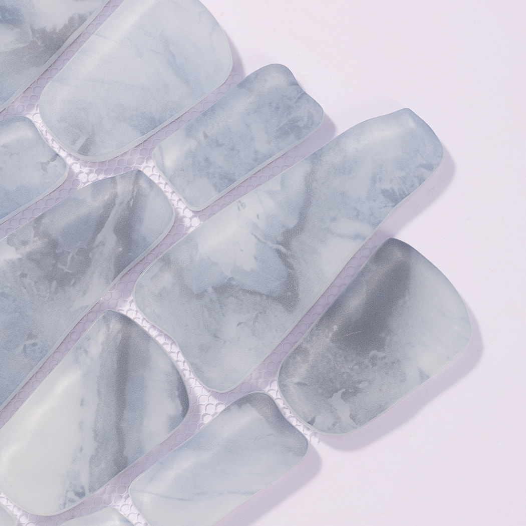 Close-up of blue gray irregular glass pebble mosaic tile pieces on mesh backing
