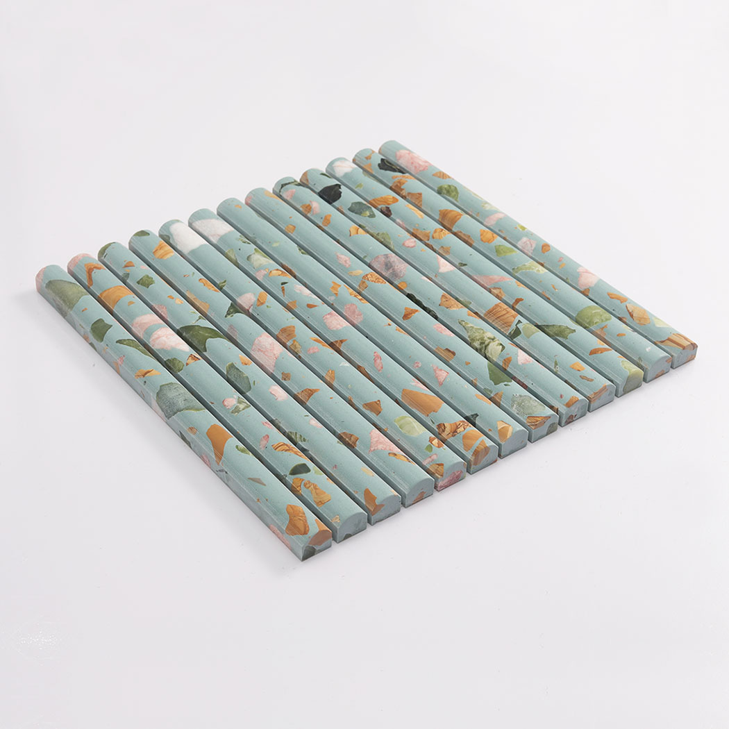 Side view of blue green terrazzo rounded fluted mosaic tile on a white background