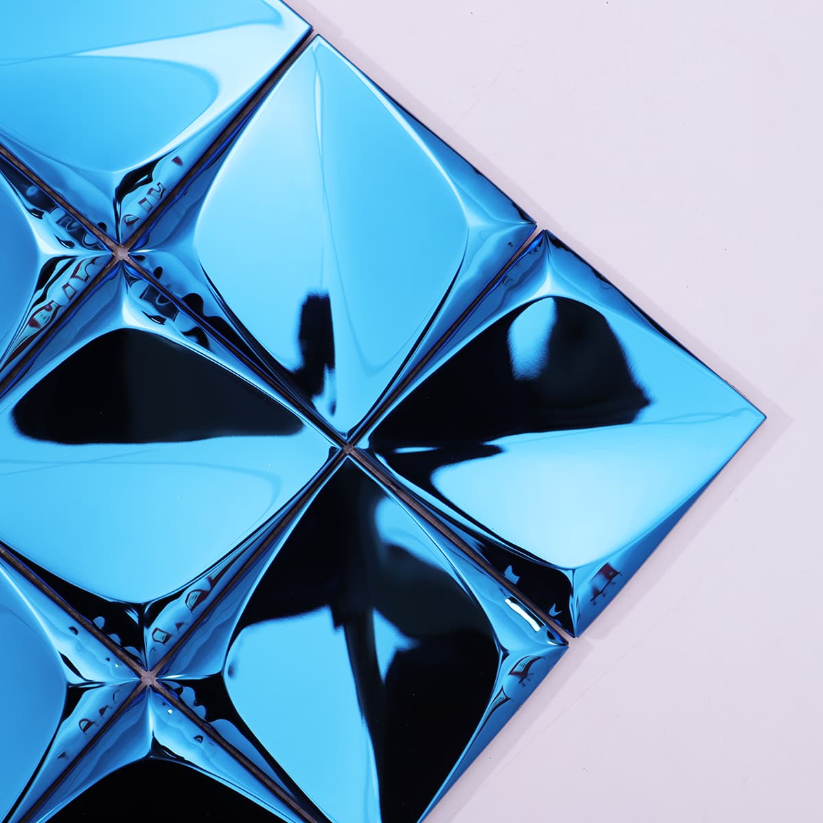 Angled view showing reflective blue 3D metal pyramid mosaic surface