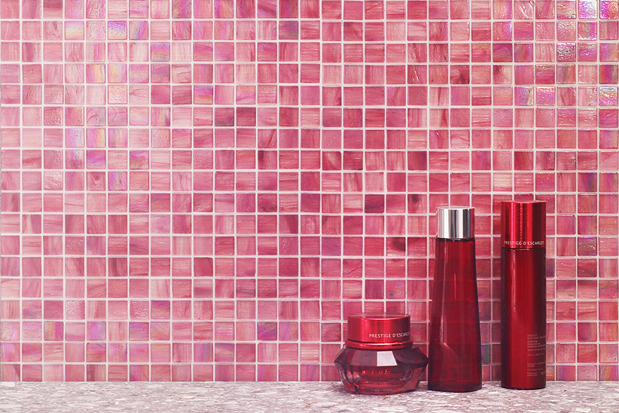 Blush pink iridescent glass square tiles with gold-infused pigment for vanity wall.
