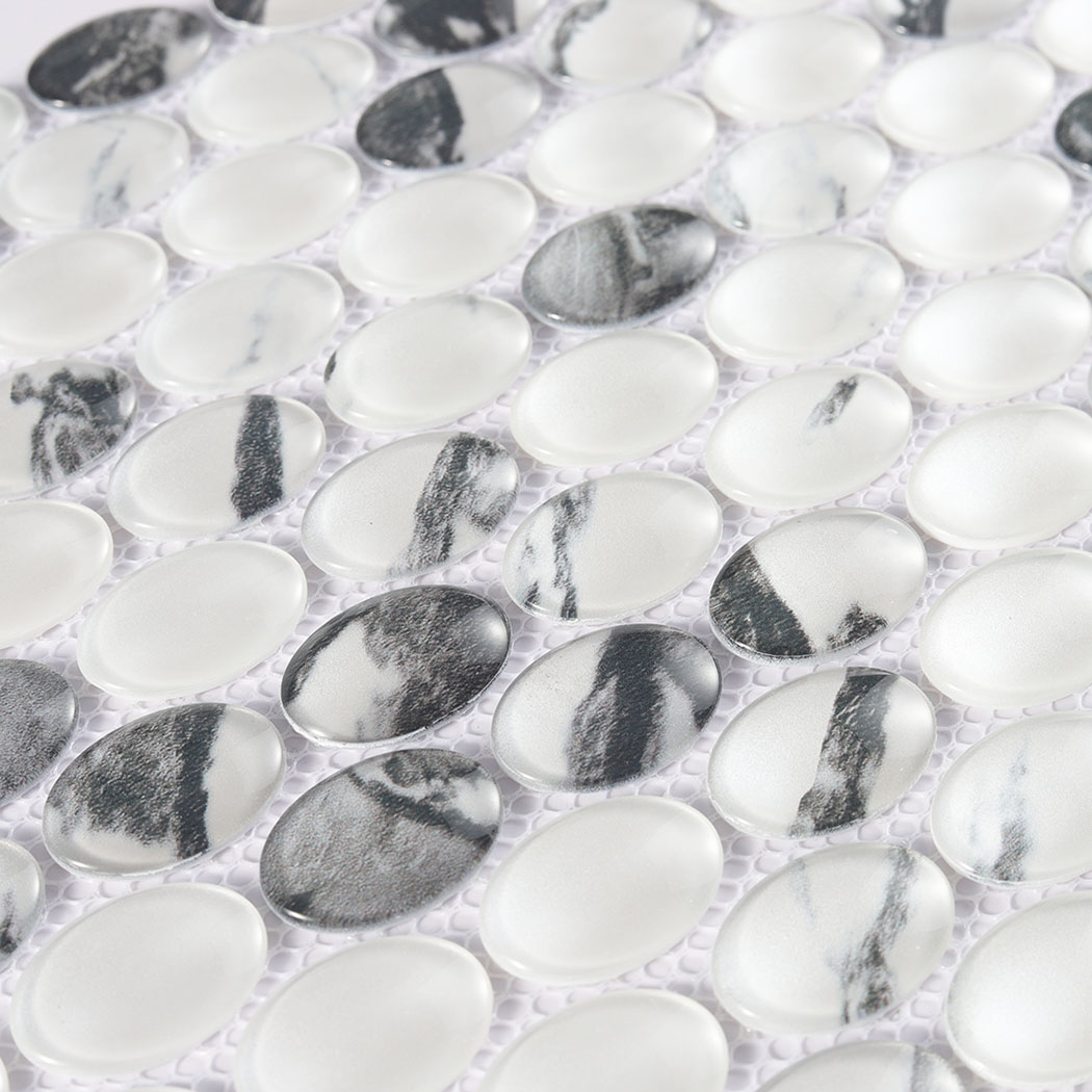 Close view of white oval glass mosaic with bold black gray veined patterns
