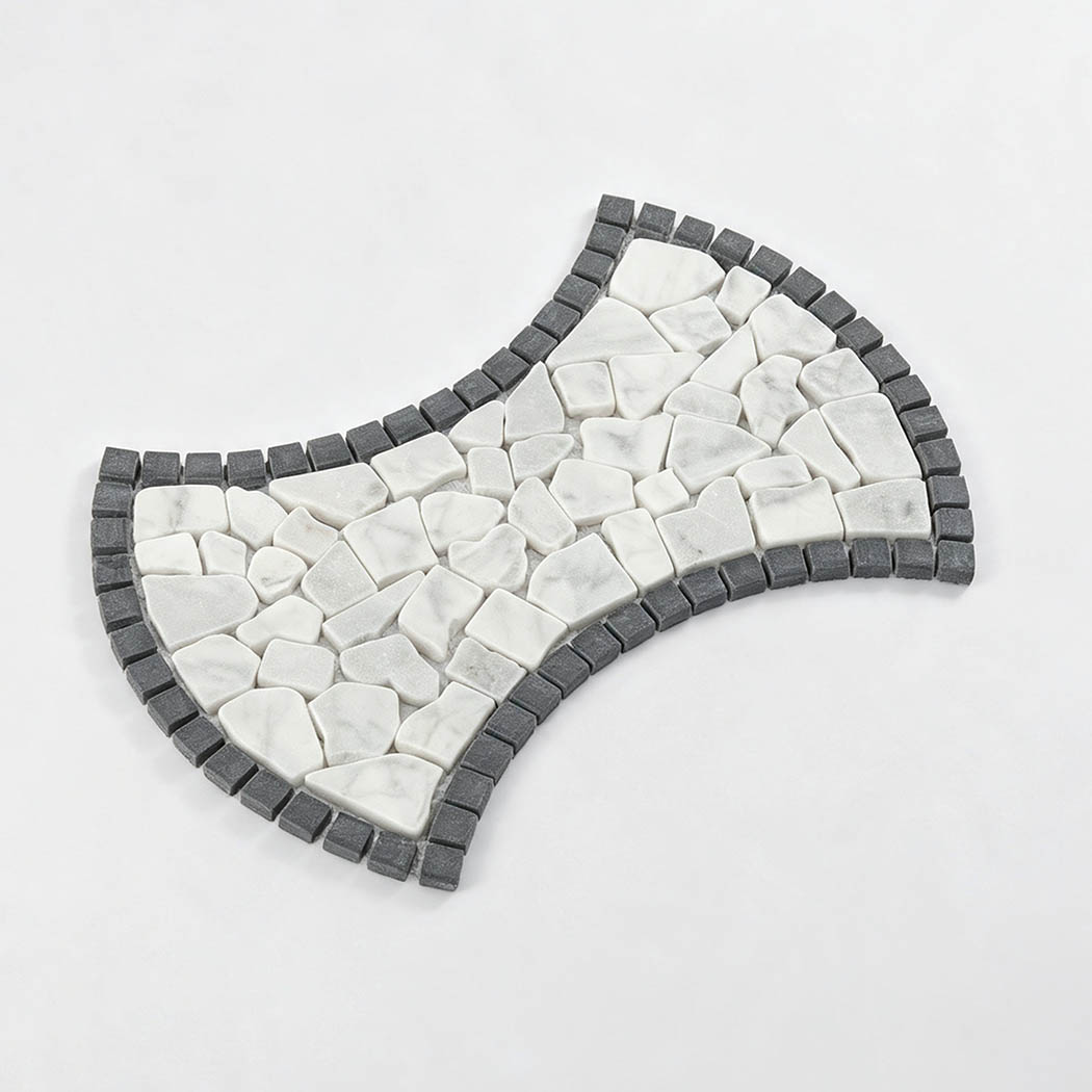 Angled view of bow tie shaped white marble pebble mosaic with charcoal border
