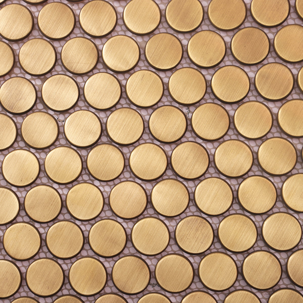Close-up of brushed gold round mosaic tiles arranged in a uniform pattern
