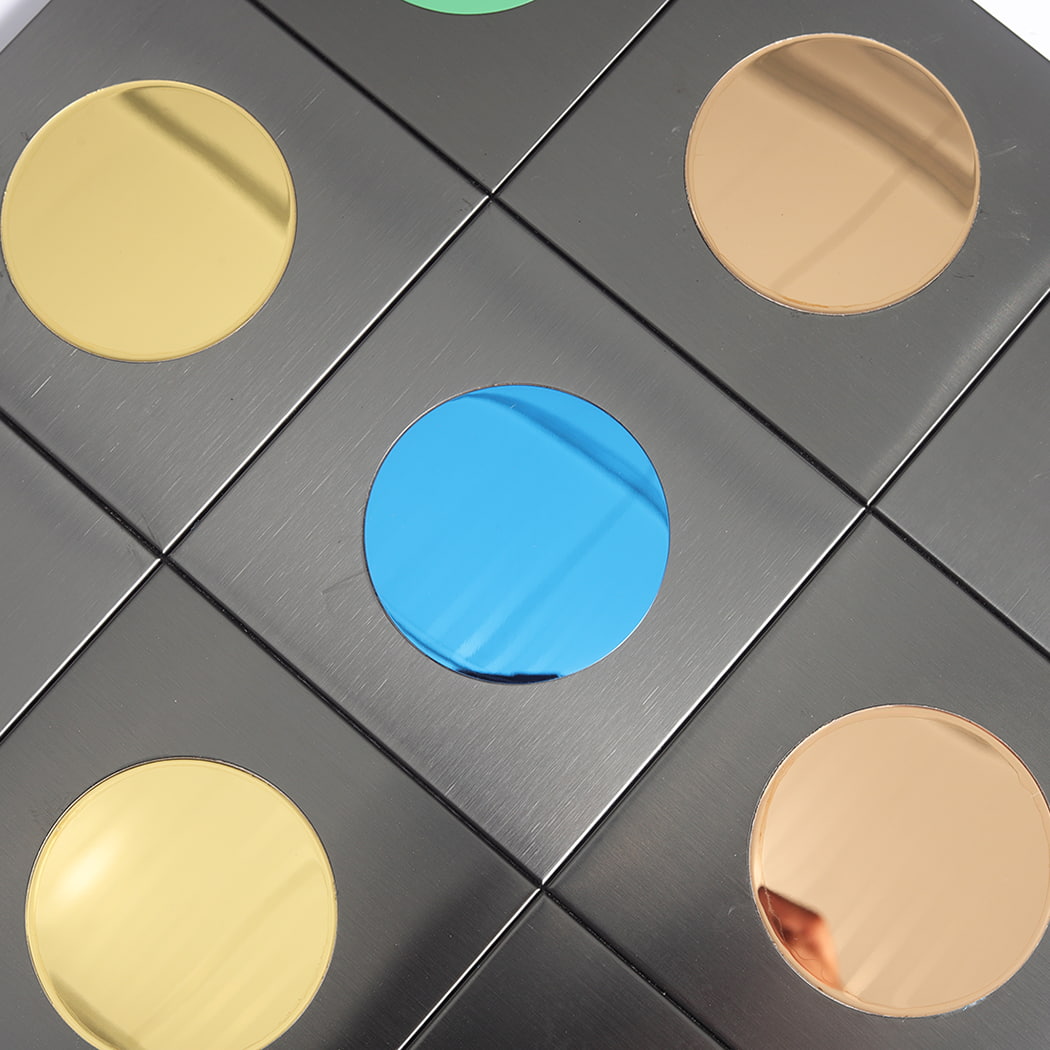 Close up shot focusing on a blue circular mirror tile surrounded by gold and bronze tiles.