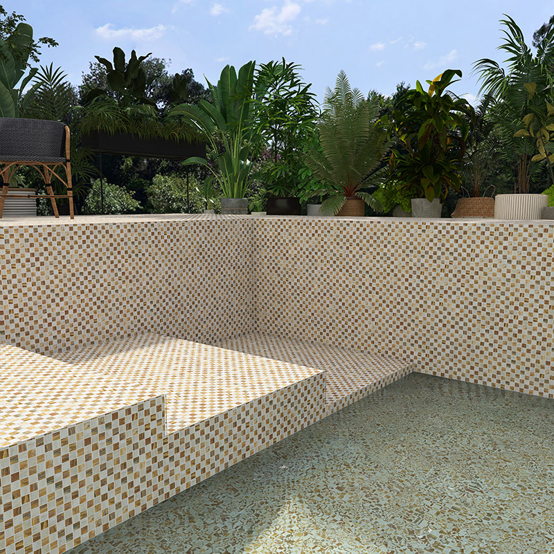 Checkered pool tiles in a modern outdoor swimming pool with lush green plants around.