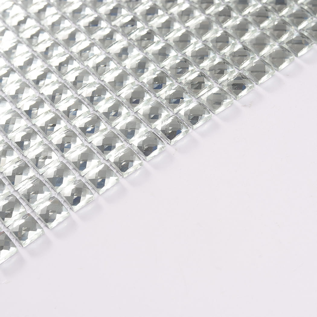 Angled view of individual clear glass mosaic tile chips showing their thickness.