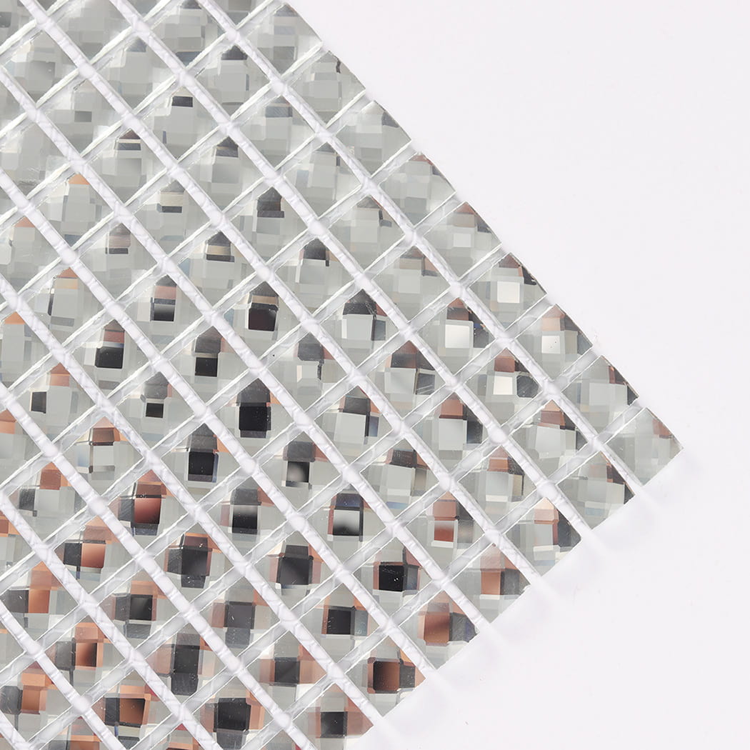 Close-up angled corner of a clear glass mosaic tile sheet on white.
