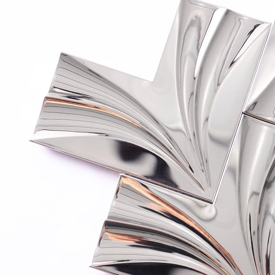 Close-up detail of chrome 3D stainless steel chevron tile surface