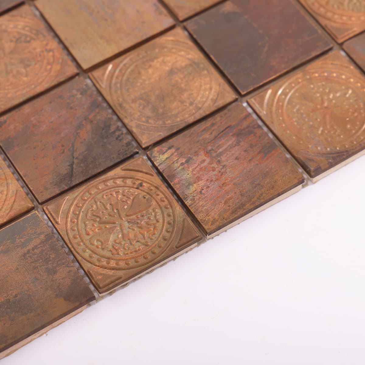 Edge detail of copper mosaic tile with vintage coin embossing