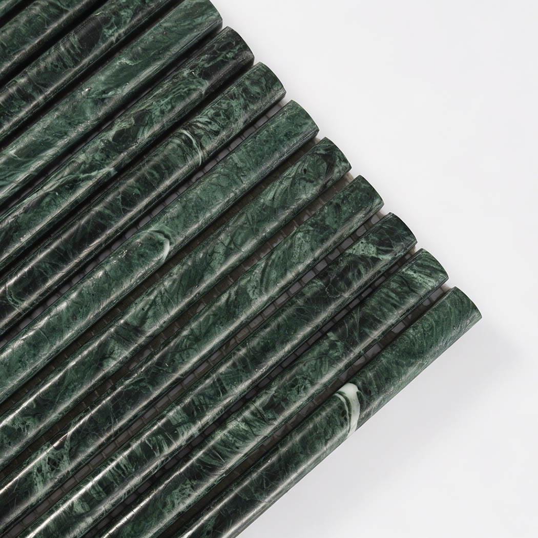 Close up corner view of dark green marble rounded strip mosaic tile with rich veining