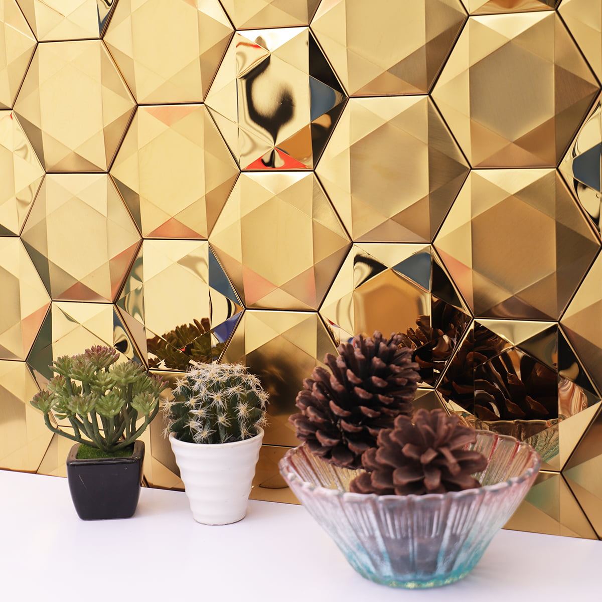 Close-up view of gold hexagonal tiles with reflective surface and small decorative items