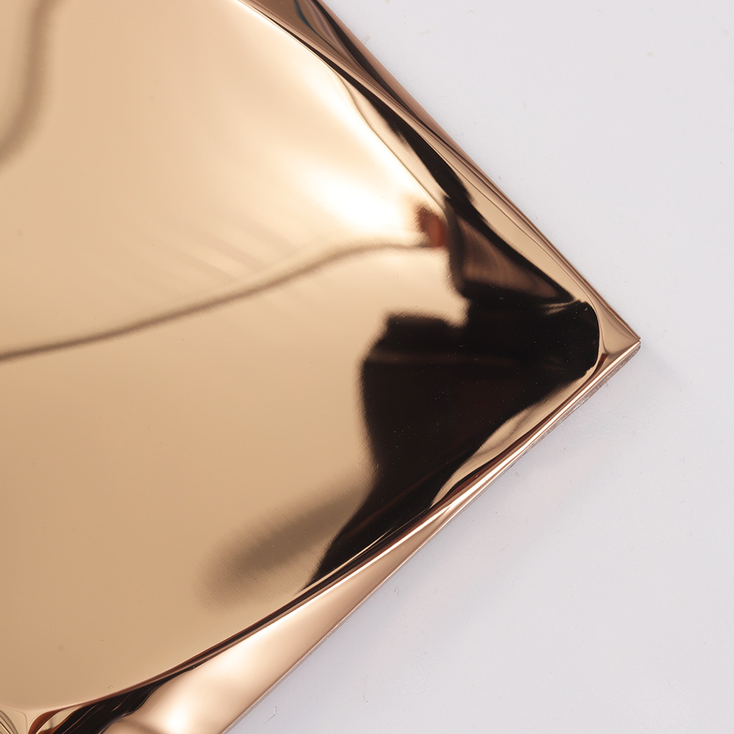 A detailed close-up shot of the corner of a rose gold 3D tile showing the smooth metallic surface.