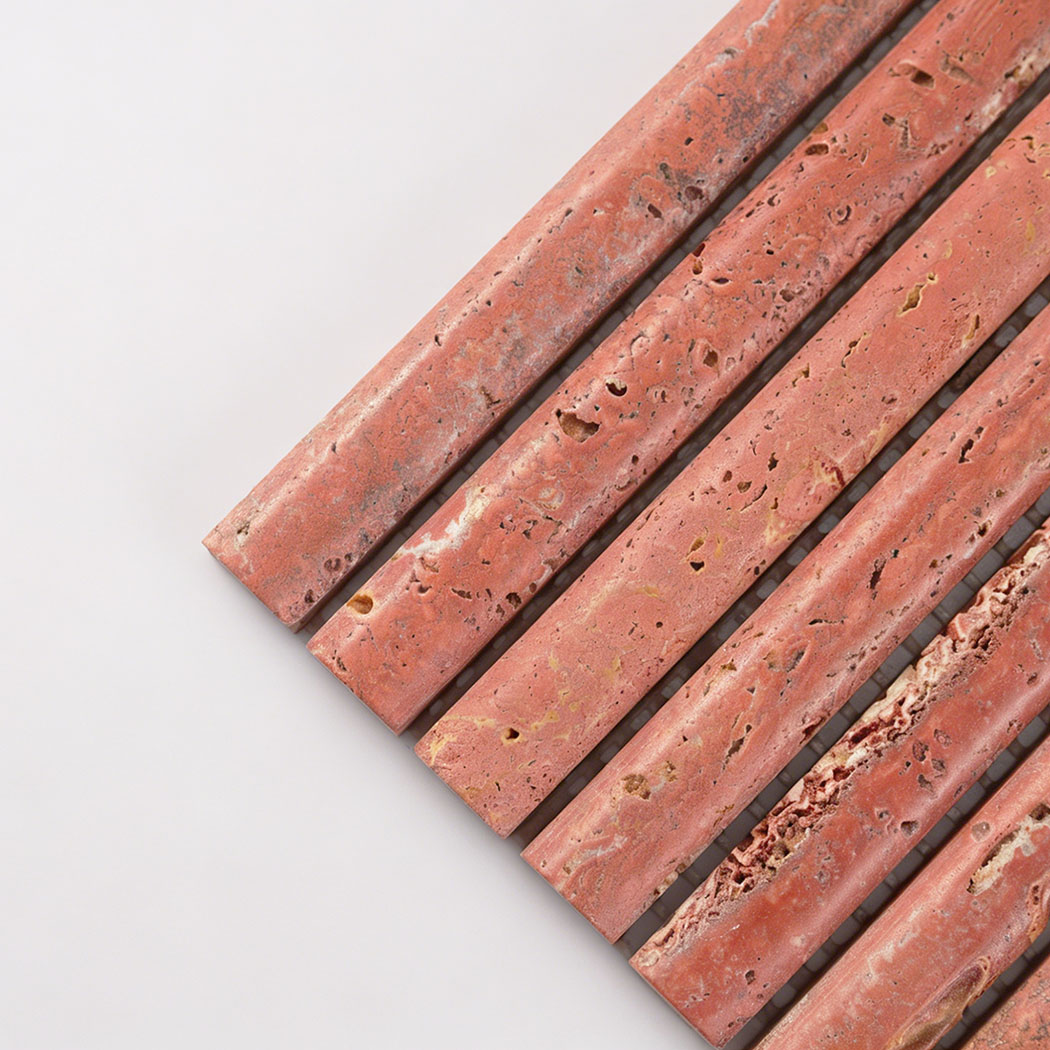 Close up corner view of red travertine fluted mosaic tile showing natural pores