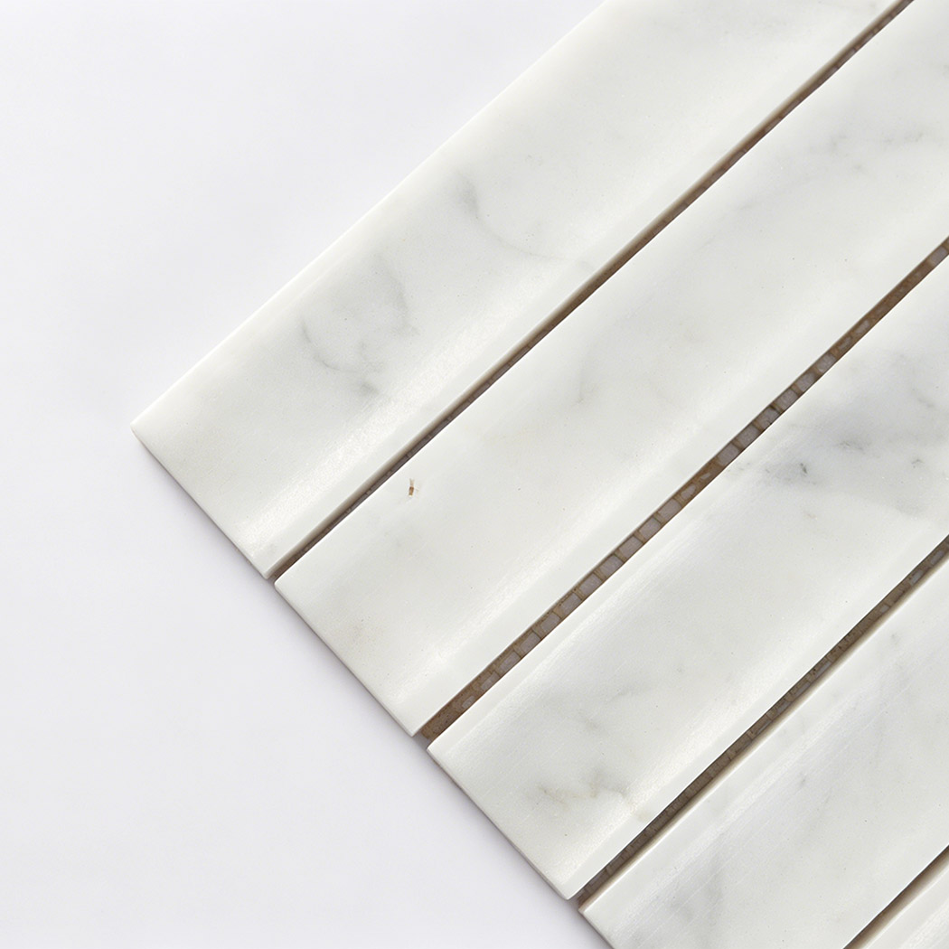 Close up corner view of white marble curved fluted mosaic tile with polished strips