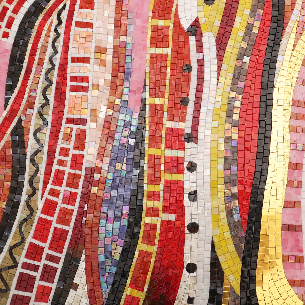 Close-up of handmade horse mosaic with red, yellow, and black tiles