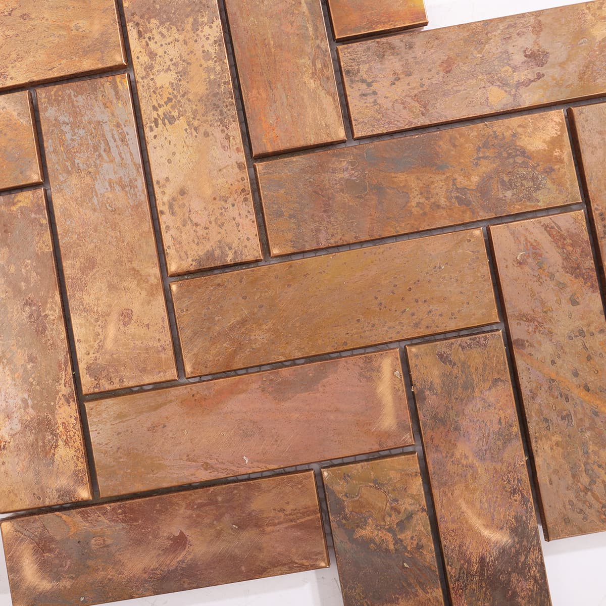Detailed texture of aged copper finish on herringbone mosaic