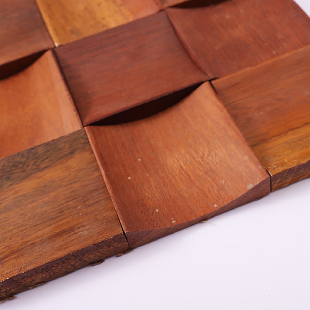 Corner close-up showing depth and shape of curved wood tile