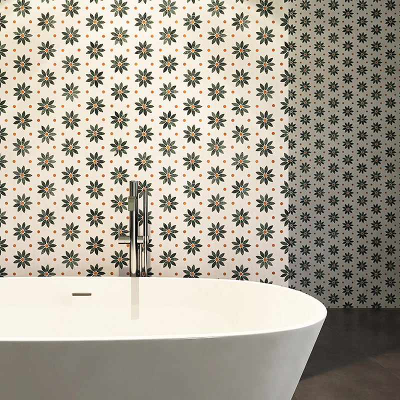 Close view of daisy marble mosaic wall tiles behind a white freestanding bathtub