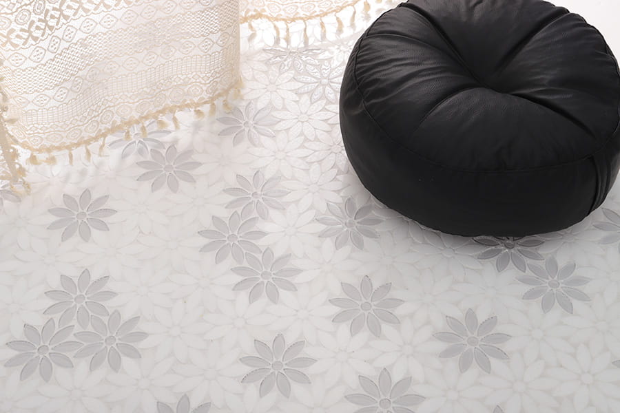 Elegant daisy mosaic tile flooring in white marble with decorative floral pattern and lace curtain