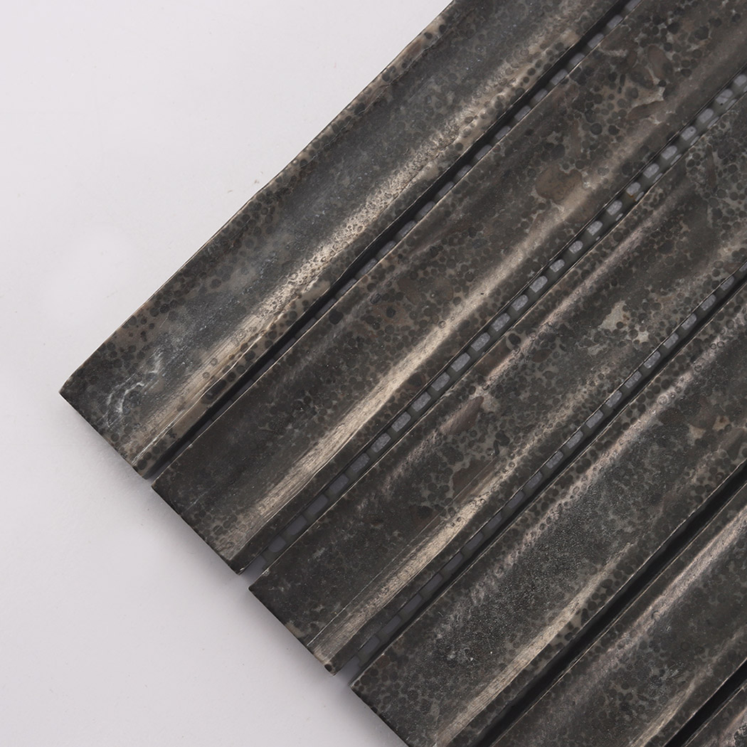 Corner detail of dark brown fluted marble tile with grooved linear surface