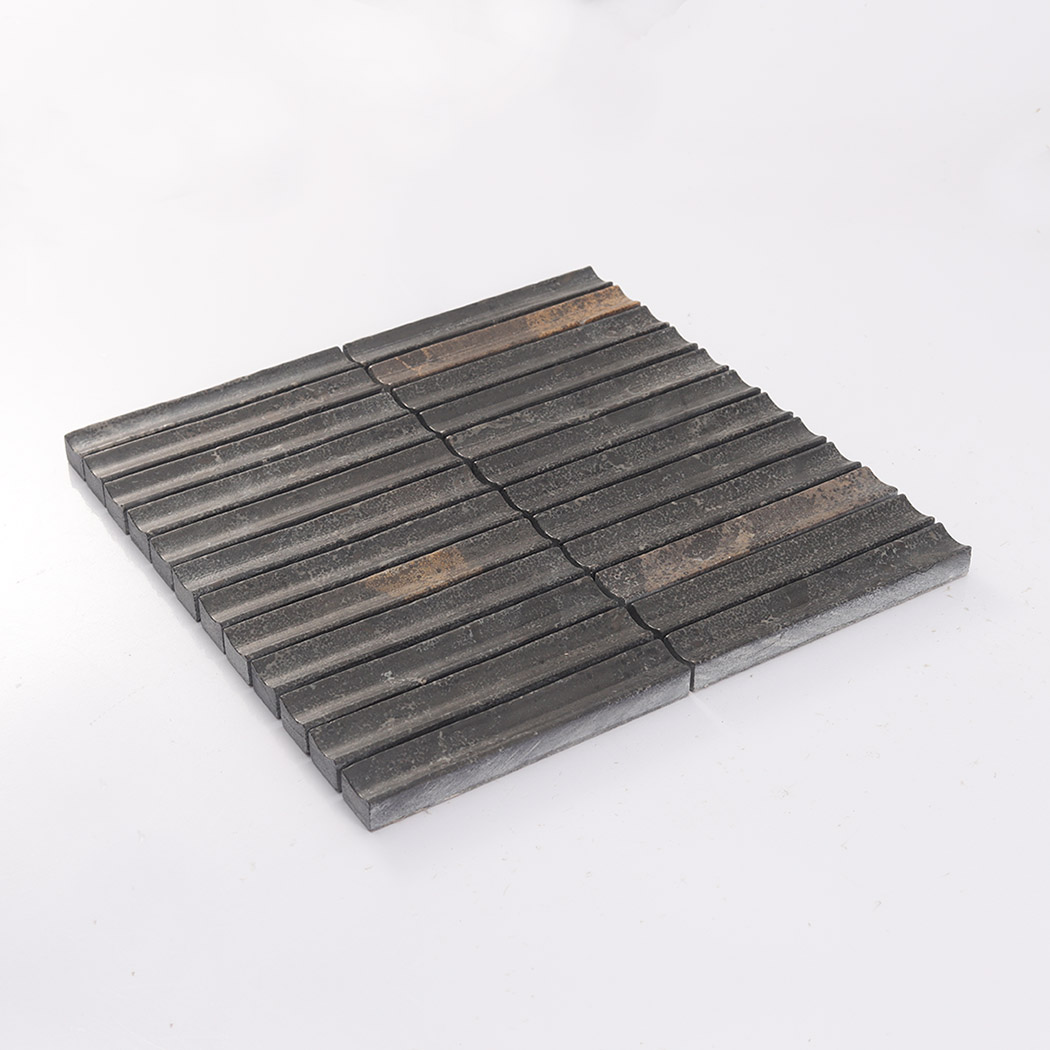 Angled view of dark brown linear fluted marble mosaic tile on white background