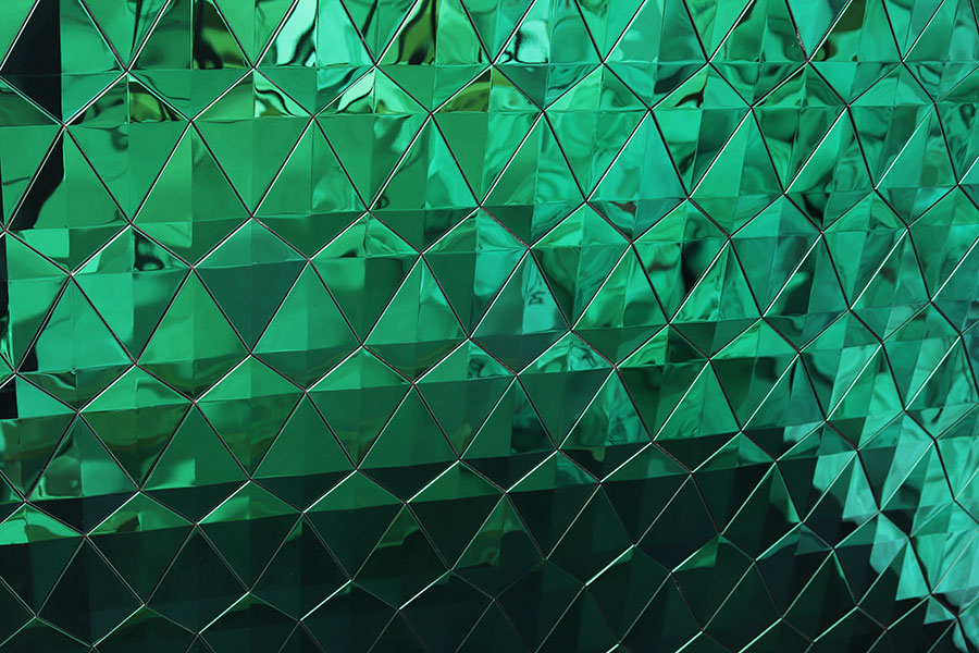 Close-up of Dark Green Tiles featuring 3D triangle relief and polished metallic texture.