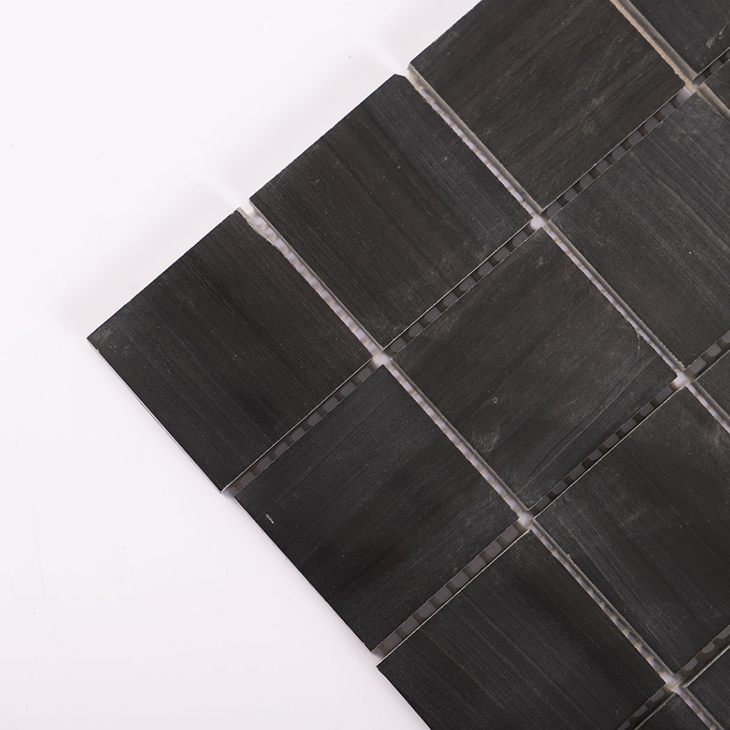 Close-up of the corner of dark grey marble mosaic tile squares.