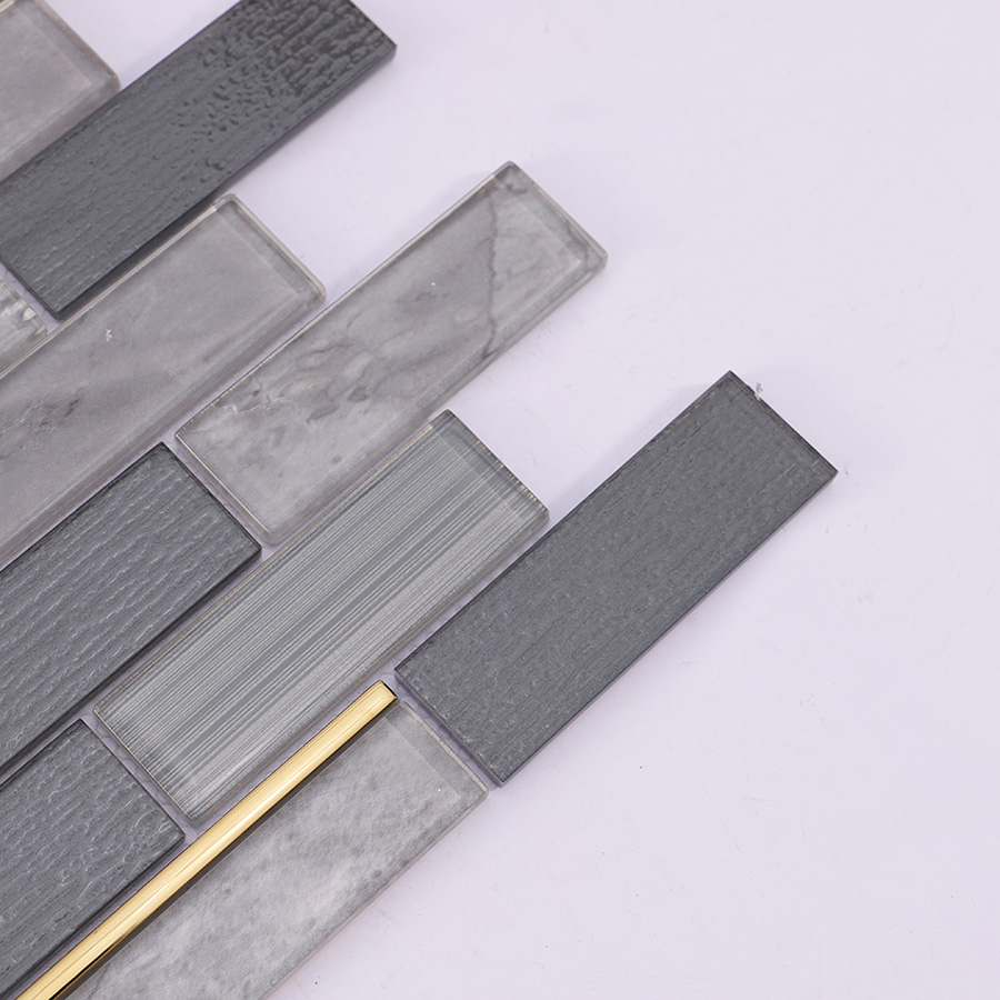 Close up of dark grey subway glass wall tile showing texture and gold line detail