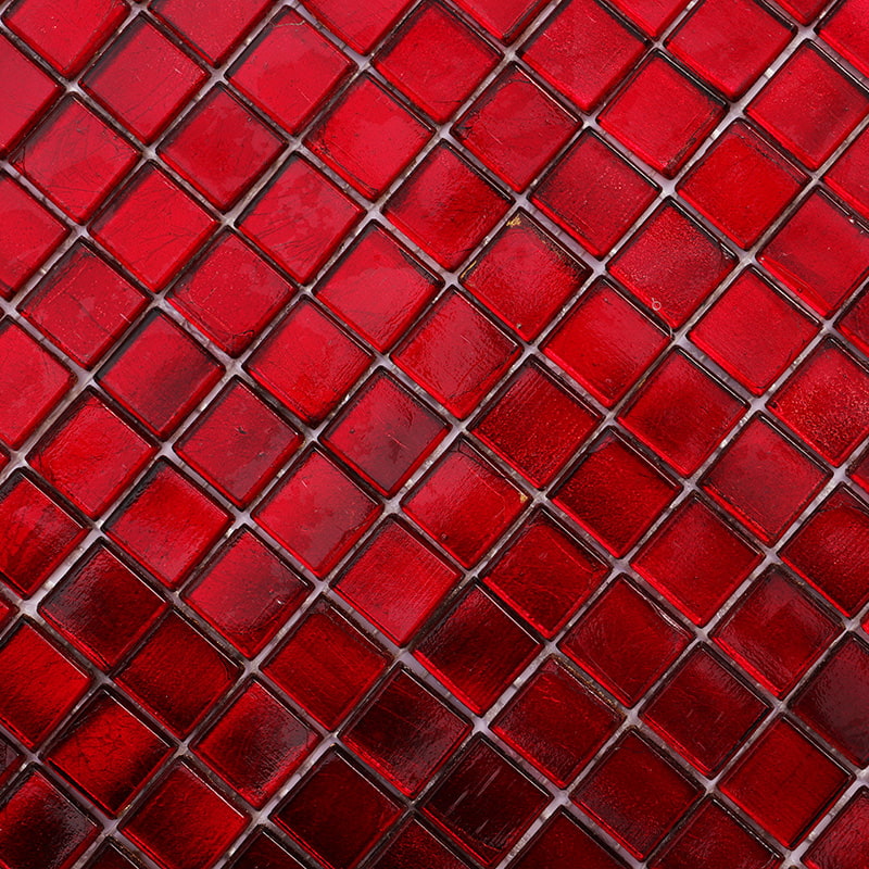 Close-up of vibrant dark red glass mosaic tiles with a glossy finish 