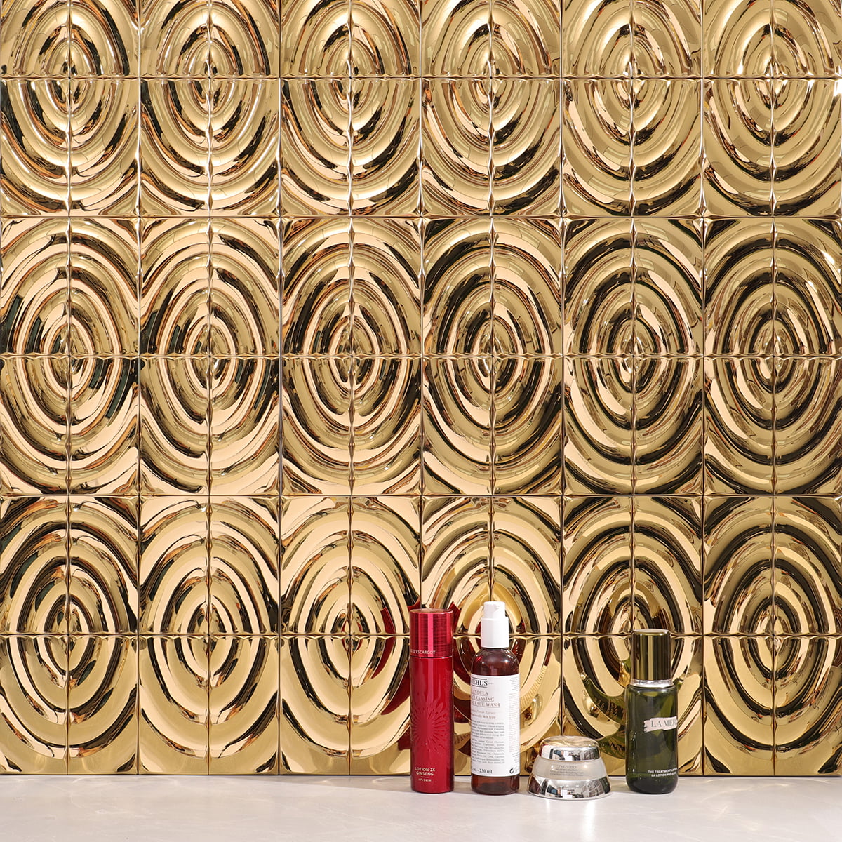 A close-up of gold wavy tiles with decorative products placed in front 