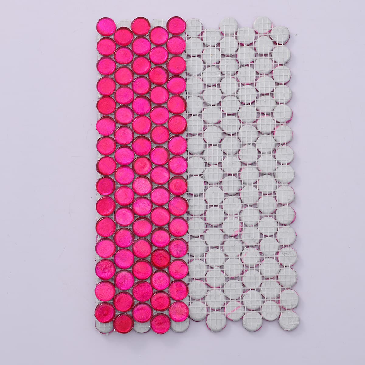 Front and back of deep pink round glass mosaic tile with mesh backing