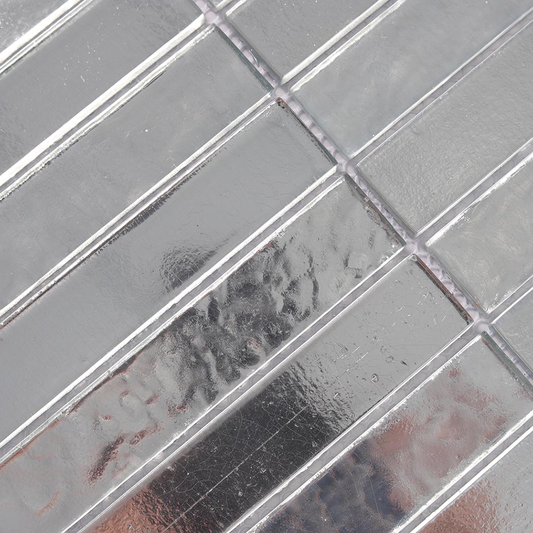 Diagonal top view focusing on the glossy, metallic surface of silver tile strips.