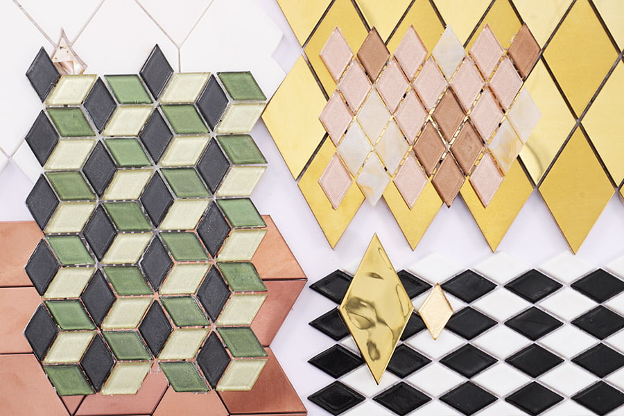 Assorted diamond shape mosaic tiles in glass and metal arranged for visual display