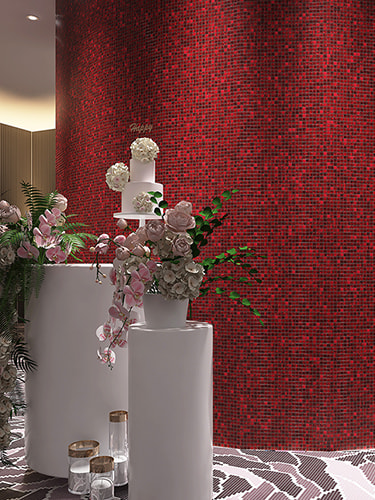 Close-up of a red mosaic tile curve highlighted by elegant flower arrangements