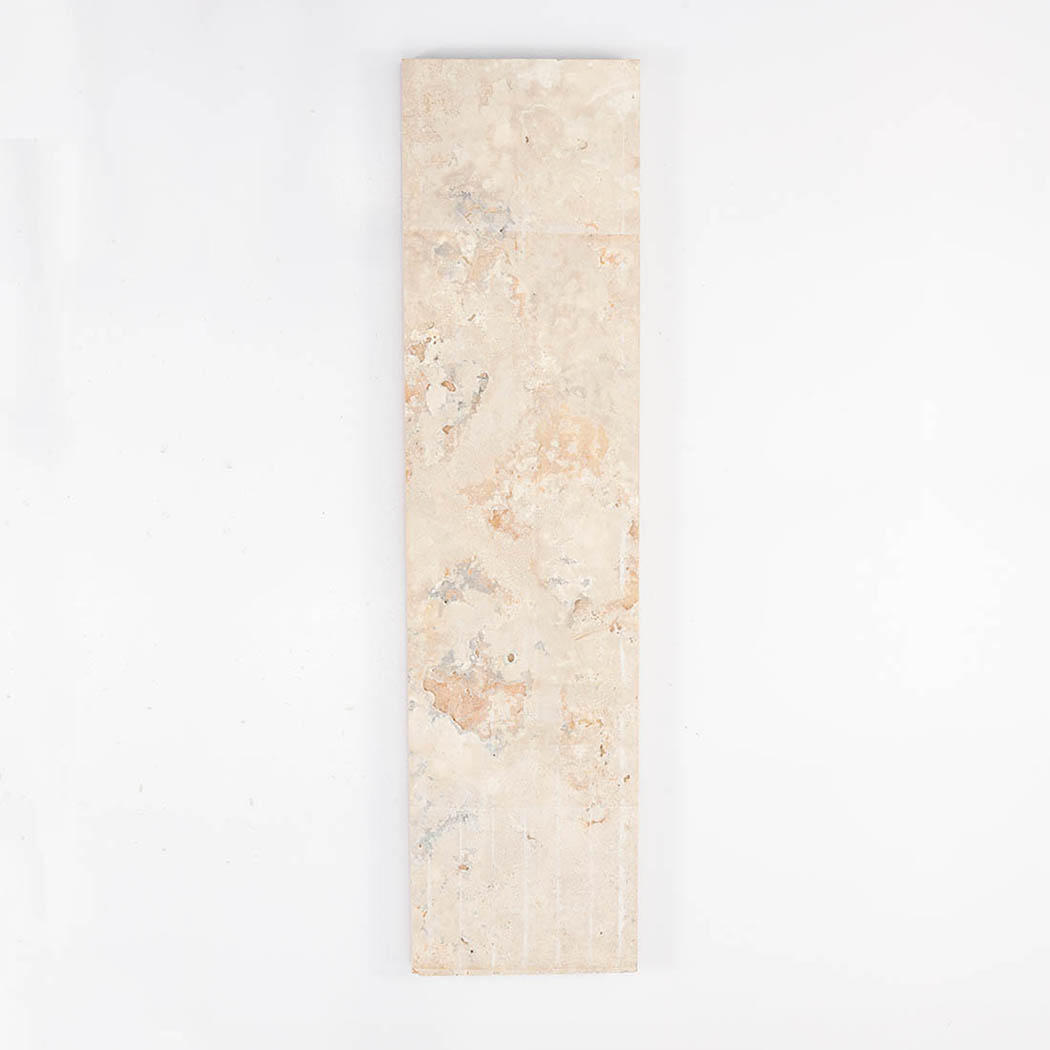 The flat unpolished back side of a beige travertine stone tile showing natural patterns.