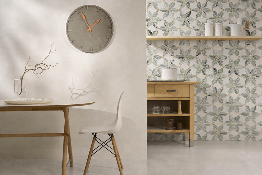 Modern dining area beside a kitchen wall finished with green floral marble mosaic tiles