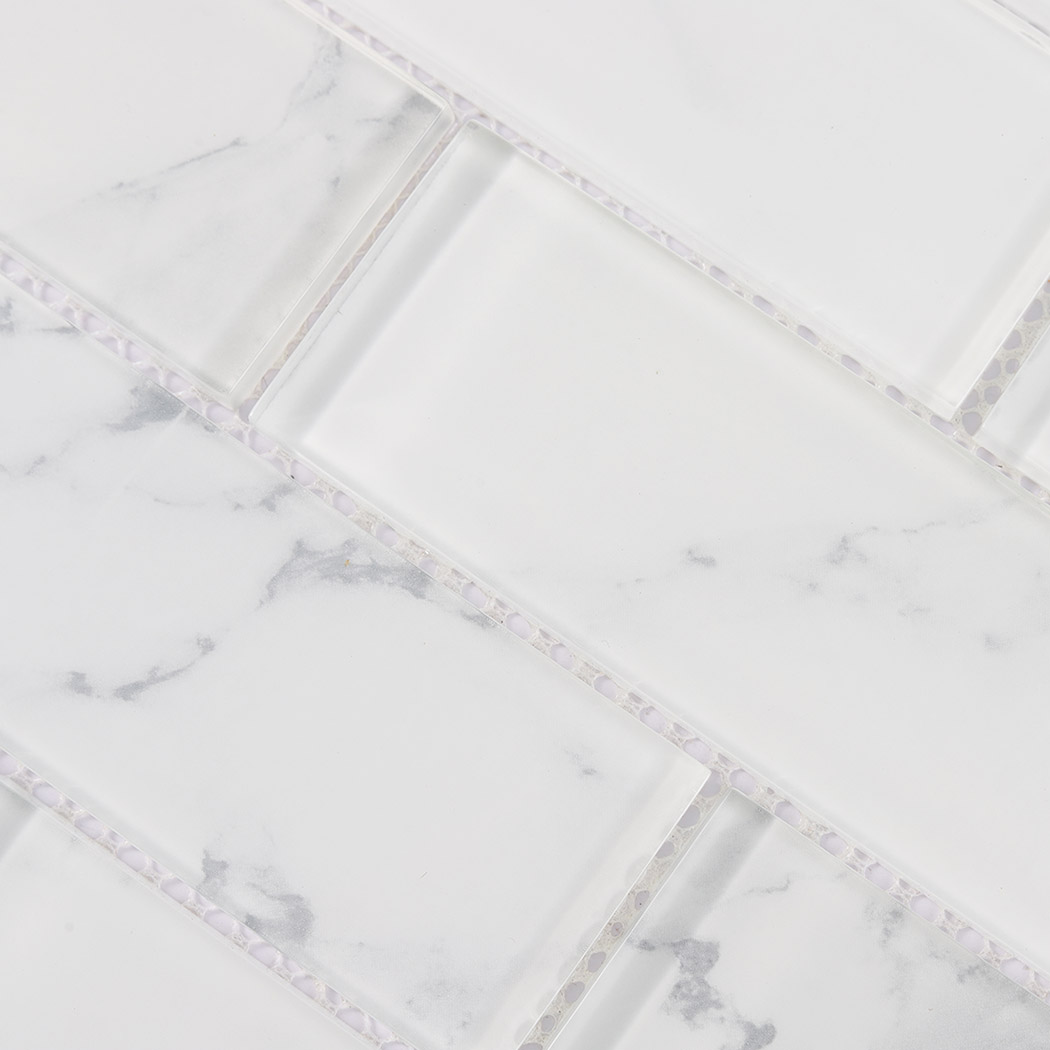 Pale white glass subway tile detail with beveled edge and gray marble veining