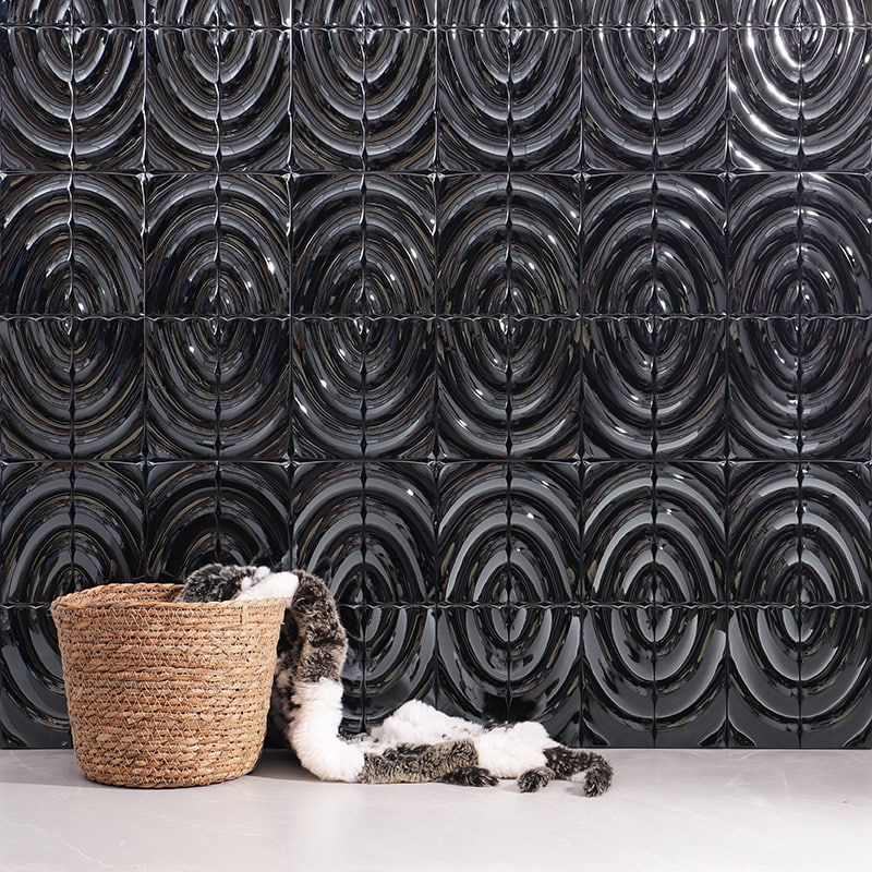 Glossy black concentric circle 3D tile wall featuring a wicker basket draped with fur throw 