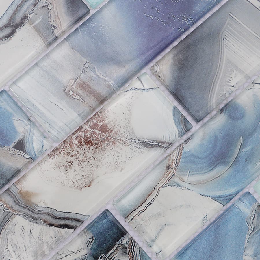 Surface detail of glossy blue grey glass mosaic tile with abstract marble veins
