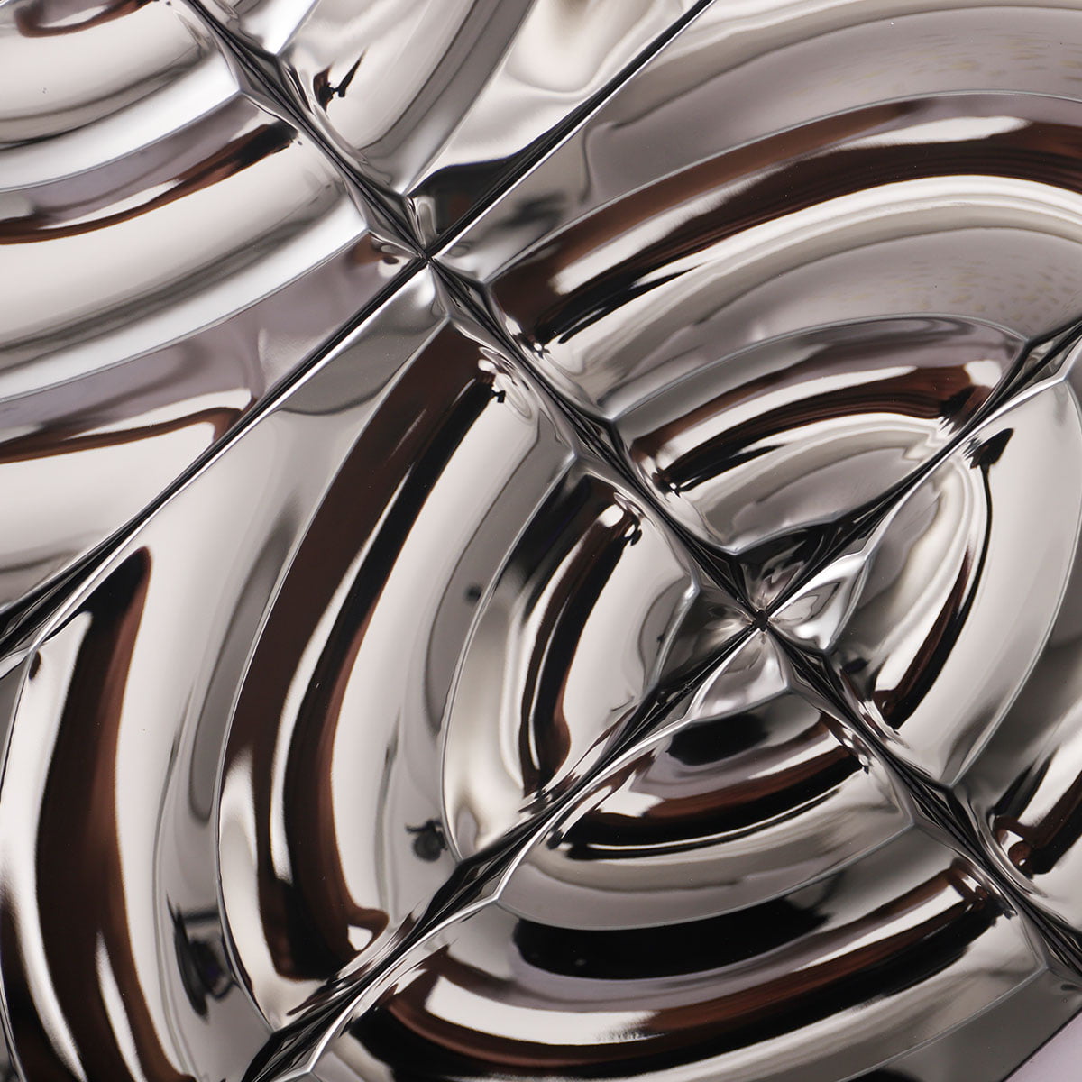 Close-up view of metallic tiles arranged in a wavy design with glossy finish 