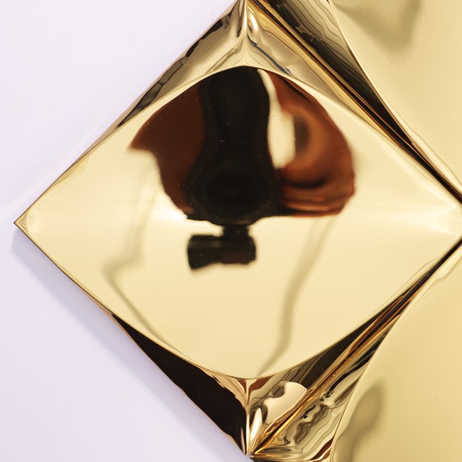 Close-up of gold 3D tile with strong reflection