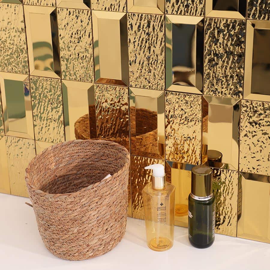 Closeup of gold beveled textured wall tiles with decor