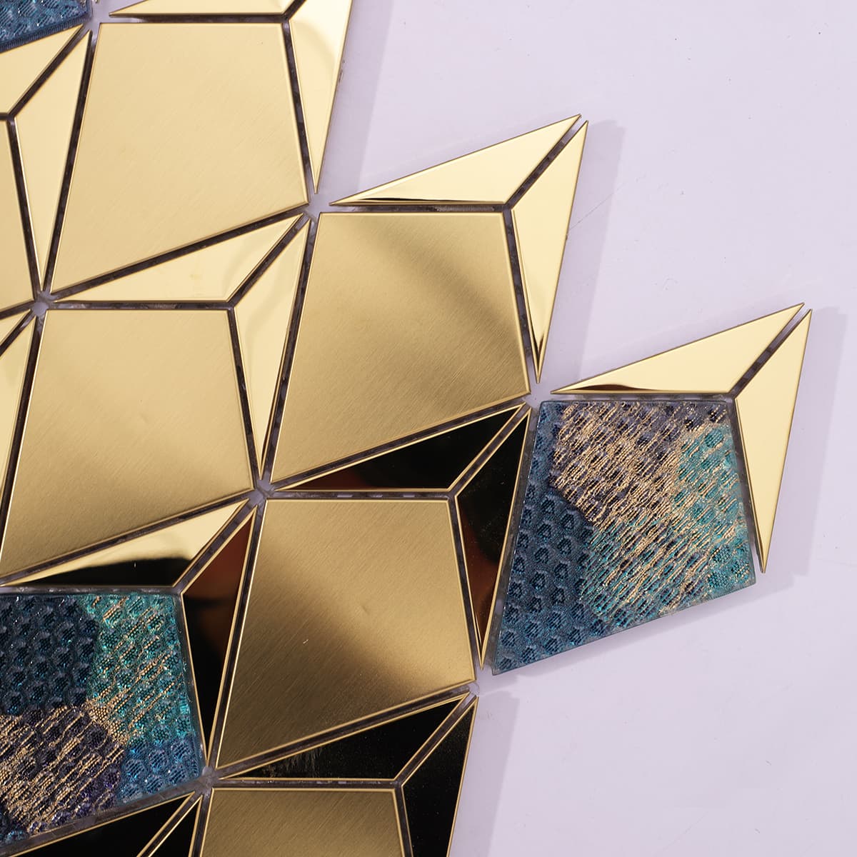 Close-up of brushed and mirror finish gold diamond metal tiles