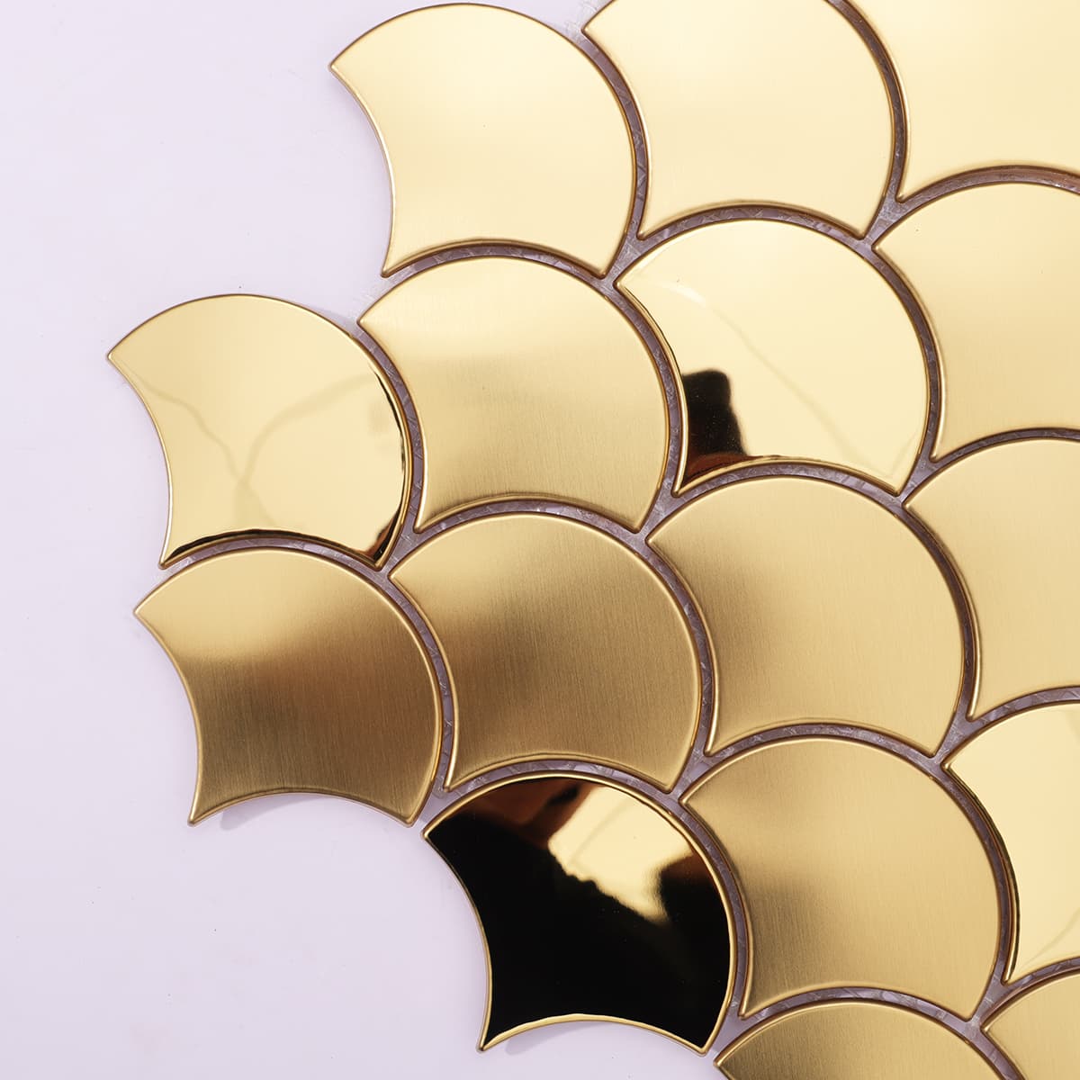 Edge detail of gold brushed and mirror fish scale tile