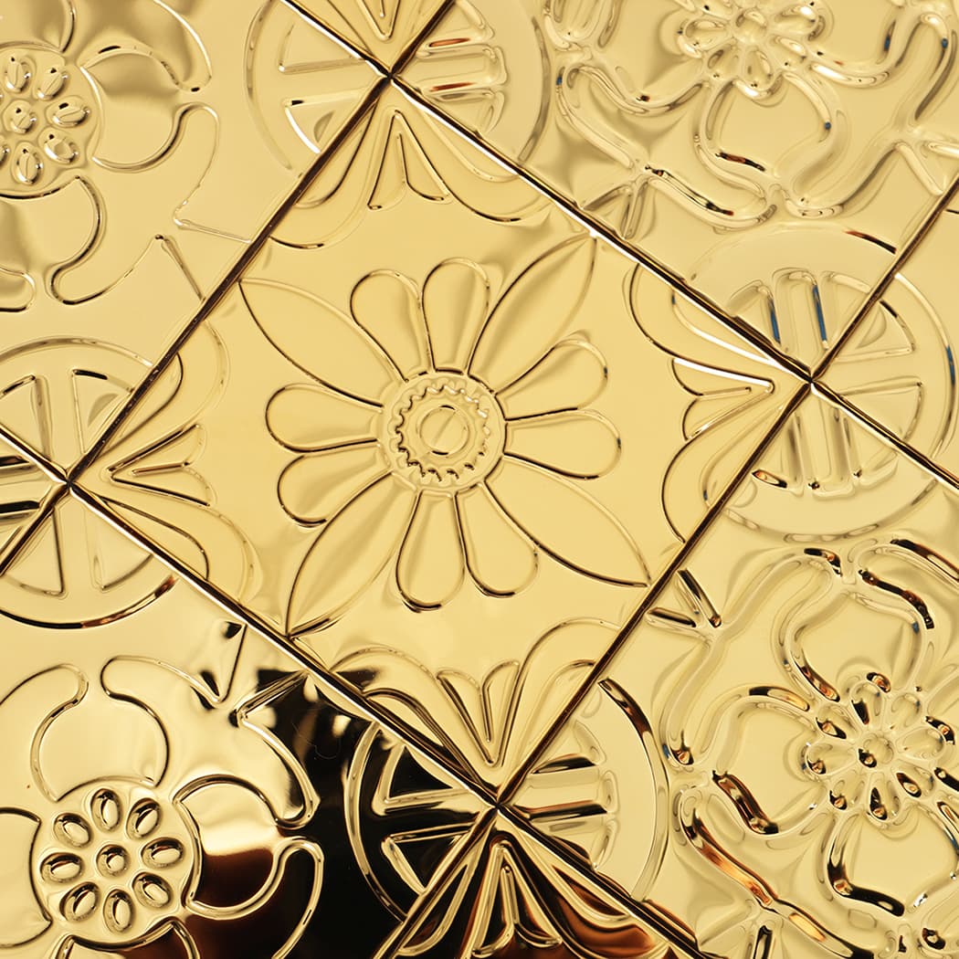 Close-up of mixed floral patchwork squares with bright highlights across the gold surface