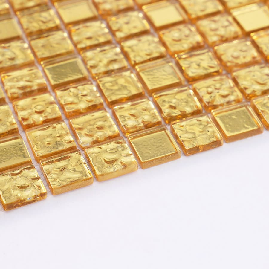 Side angle view of textured gold glass mosaic tile sheet.