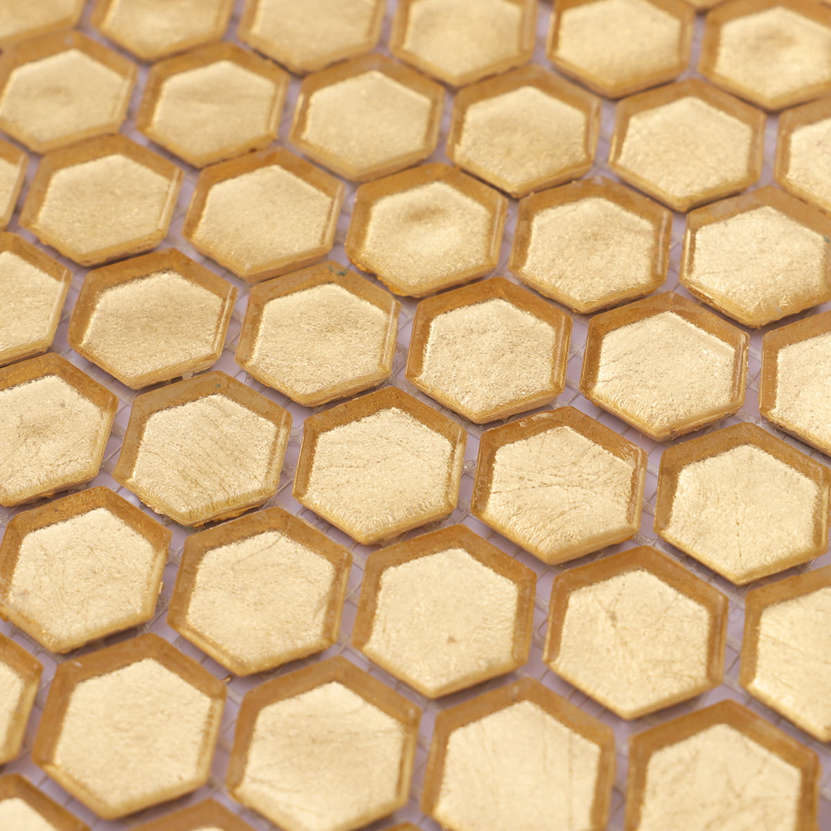 Detailed close-up of gold hexagon glass tiles with soft reflective surface