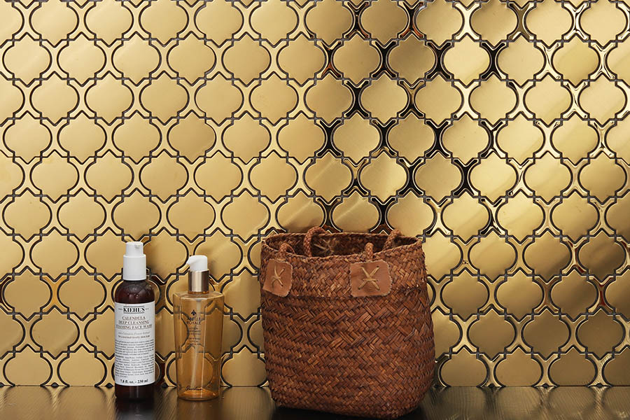 Gold lantern metal mosaic tile wall with woven basket and bottles